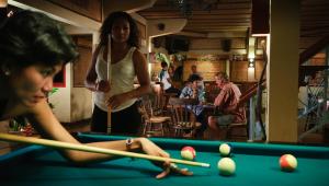 a woman standing next to a pool table at Strawberry Hill Hotel & Restaurant in Bedugul