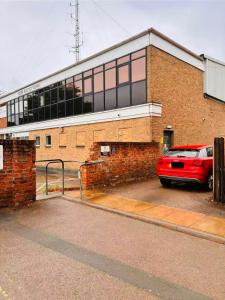 a red car parked in front of a brick building at Gillygate Guest House in York