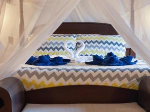 a bed with blue pillows and a swan on it at Villa Azulejo in Black Rock