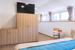 a bedroom with a large wooden cabinet and a table at Penzion Rališka in Horní Bečva