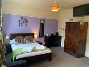 a bedroom with a bed and a purple wall at Gillygate Guest House in York
