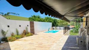 a backyard with a swimming pool and a patio umbrella at Cachoeira Paulista Espaço Cassicay in Cachoeira Paulista
