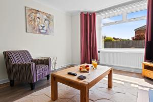 a living room with a chair and a coffee table at Great Sutton House Perfect for Contractors in Sutton