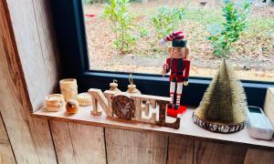 a shelf with a nutcracker and christmas decorations on a window at La Noisette in Florennes