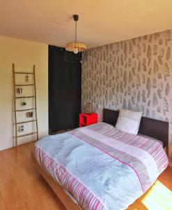 a bedroom with a bed with a blue comforter at Calme entre pins et océan in Onesse-et-Laharie