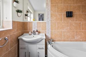a bathroom with a sink and a bath tub at Great Sutton House Perfect for Contractors in Sutton +33 photos