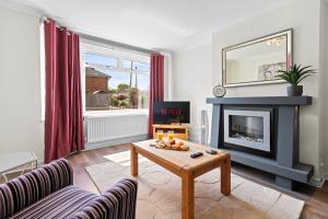 a living room with a fireplace and a table at Great Sutton House Perfect for Contractors in Sutton