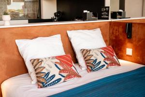 a bed with two pillows on top of it at Cap Cosy studio standing Naturiste Heliopolis Cap d'Agde with Sea View in Cap d'Agde