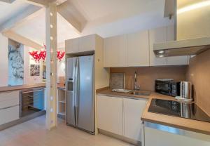 a kitchen with white cabinets and a stainless steel refrigerator at Appartement DELICE A in Saint-Tropez +12 photos