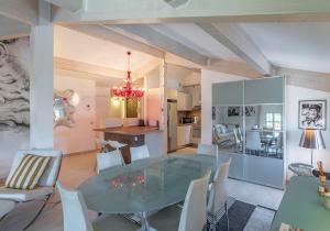 a dining room and kitchen with a glass table and chairs at Appartement DELICE A in Saint-Tropez
