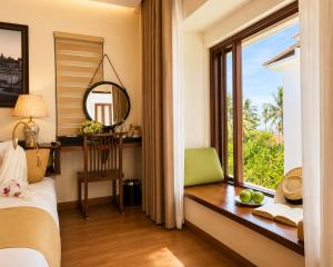 a bedroom with a bed and a window with a mirror at Happy Life Memories Hoi An Hotel & Spa in Hoi An