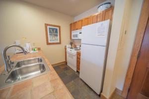 a kitchen with a white refrigerator and a sink at Red Hawk Lodge 2297 by SummitCove Lodging in Colorado in Keystone