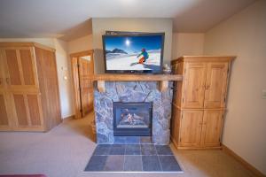 a living room with a fireplace with a tv over it at Red Hawk Lodge 2297 by SummitCove Lodging in Colorado in Keystone