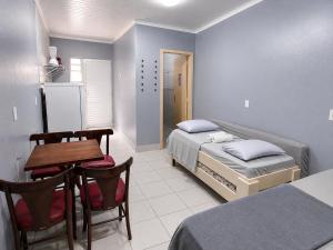 a bedroom with a bed and a table and chairs at Recanto dos Pássaros 306C Até 10x Sem Juros no Cartão Direto com a Propriedade in Itapema