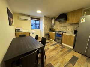 a kitchen with a wooden table and a refrigerator at Arriendo habitaciones Talca in Talca