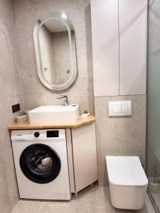 a bathroom with a washing machine and a sink at NV Apartments 2 in Volodymyr-Volynskyi +10 photos