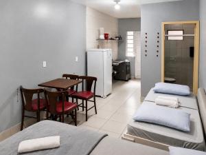 a room with three beds and a table and a refrigerator at Recanto dos Pássaros 306C Até 10x Sem Juros no Cartão Direto com a Propriedade in Itapema