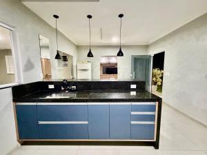 a kitchen with blue cabinets and a sink at chácara 3A-2 in Pôrto Feliz
