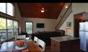 a kitchen and living room with a table and a couch at Green Castle cabin on the Shenandoah River in Luray