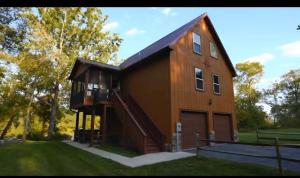 a large wooden house with a porch and a balcony at Green Castle cabin on the Shenandoah River in Luray