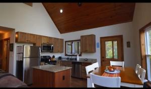 a kitchen with a table and a kitchen with a refrigerator at Green Castle cabin on the Shenandoah River in Luray +3 photos