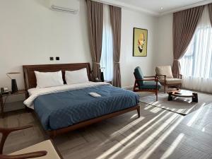 a hotel room with a bed and a chair at ASFARO Apartments in Abuja +50 photos