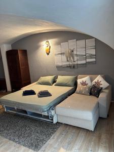 a bed and a couch in a room at Appartamento Grangia Rigat, Bousson, Cesana Torinese in Bousson