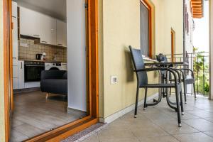 a balcony with a table and chairs and a kitchen at Apartmaji Tinta in Kanal