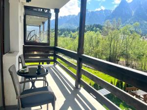 a balcony with a table and chairs and mountains at Riverside Lindas - Next to Train Station with Parking in Zamora
