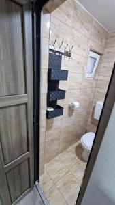 a bathroom with a toilet and a glass shower door at Casa AVA 2 Mai in 2 Mai +36 photos