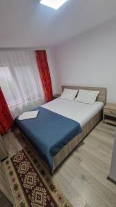 a bedroom with a bed with a blue blanket at Casa AVA 2 Mai in 2 Mai