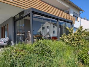 an extension of a house with glass doors and grass at Kunst am Marktplatz in Niederwerrn