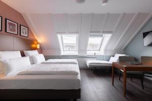 a hotel room with two beds and a desk at Garner Hotel Stuttgart City Centre by IHG in Stuttgart +118 photos