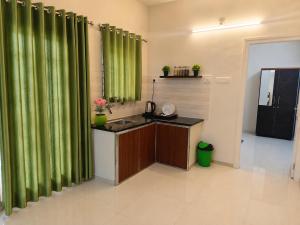 a bathroom with green curtains and a sink in a room at Krishna Theeram 150m from Temple in Guruvāyūr