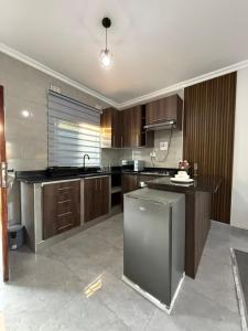 a large kitchen with wooden cabinets and a sink at WN Apartments in Lusaka