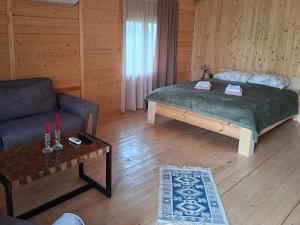a room with a bed and a couch and a table at savane mukhranshi in Mukhrani