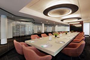 a conference room with a long table and orange chairs at Hôtel Alt Québec in Quebec City