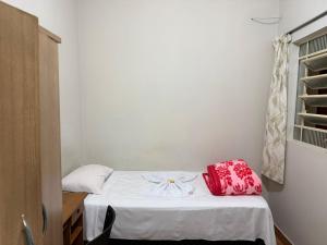 a room with a bed with a red bag on it at Hotel Boa Vista in Assis