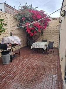 a patio with a table and chairs and pink flowers at Santa Rosa in Mendoza