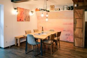 a dining room with a wooden table and chairs at Kunstwerk AppARTement in Sankt Michael im Lungau