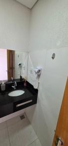 a bathroom with a sink and a mirror at Paris Flats Lagoa Santa in Lagoa Santa