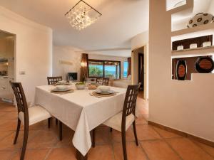 a dining room with a white table and chairs at Porto Cervo Marina Three-Bedroom House with Pool in Porto Cervo +42 photos