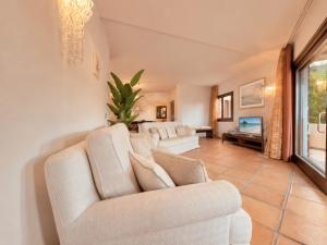 a living room with two white couches and a tv at Porto Cervo Marina Three-Bedroom House with Pool in Porto Cervo