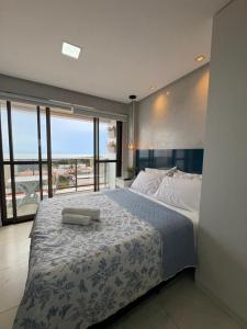 a bedroom with a large bed and a large window at STUDIO Mar azul 1206 in São Luís +97 photos