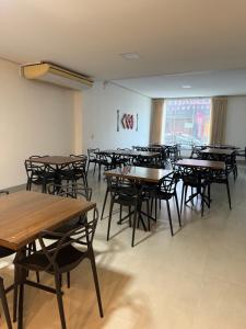 a classroom with tables and chairs in a room at Hotel São Vicente in Araguaína