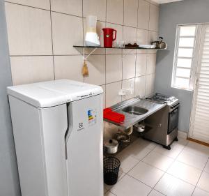 a kitchen with a white refrigerator and a sink at Recanto dos Pássaros 306C Até 10x Sem Juros no Cartão Direto com a Propriedade in Itapema