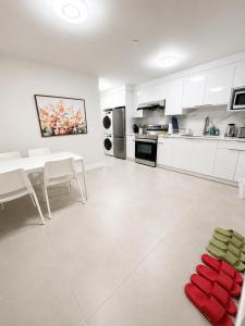 a kitchen with white cabinets and a red object on the floor at Modern Vancouver 2BR Suite Full Kitchen & Laundry in Vancouver
