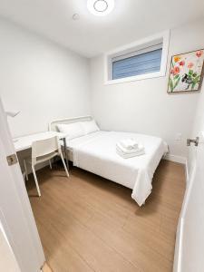 a bedroom with a bed and a desk and a window at Modern Vancouver 2BR Suite Full Kitchen & Laundry in Vancouver