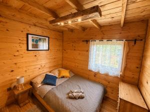 a bedroom with a bed in a log cabin at Chaty Jak Dawniej 787-330-207 in Wołkowyja