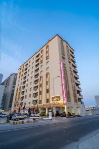a large building on the corner of a street at Fursan Apartment in Manama